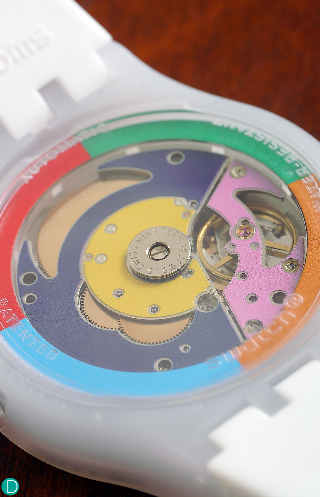 The colourful movement bridges of the Swatch Sistem 51 in white.