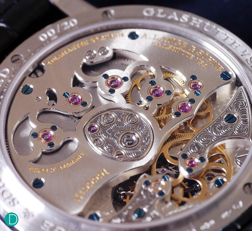The Lange caliber L961.3. With hand engraving on the two cocks and the central medallion. Note also the many inwrd and outward angles on the openings on the 3.4 plate to show the double barrels and part of the movement wheels. These are particularly difficult to execute perfectly, and the way it is delivered here shows Lange's mastery.