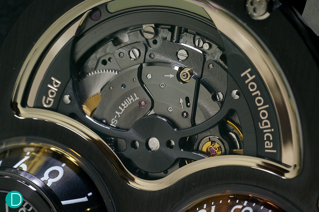 Megawind rotor. To create this effect, the movement is turned upside down to expose the rotor on the dial side. The Megawind rotor is a stylized battle-axe shape which has become iconic with MB&F.  The rotor is called mysterious, referring to the fact that the rotor appears to be symmetrically balanced, but yet for it to rotate and harness the gravitational energy to wind the watch, it needed to have an off centered weight. This is achieved by machining the under-side of one of the blades to be razor thin, reducing its mass.