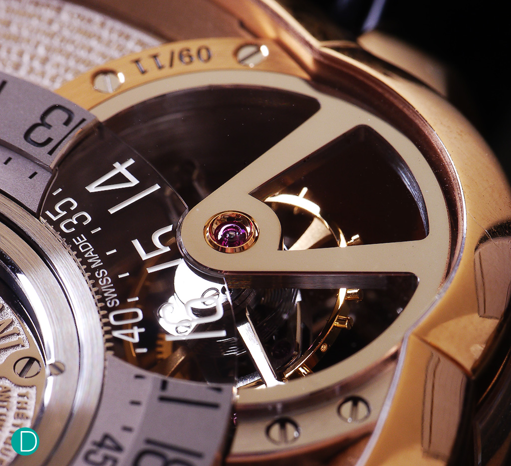 A detail of the tourbillon bridge. The bridge is specular polished, and the finishing is exceptionally well done. Note also the tourbillon staff is beautifully anglaged.To enable the tourbillon to be still visible  under the part of the dial which is cut-out, a portion of the dial is reproduced on a sapphire glass piece. 