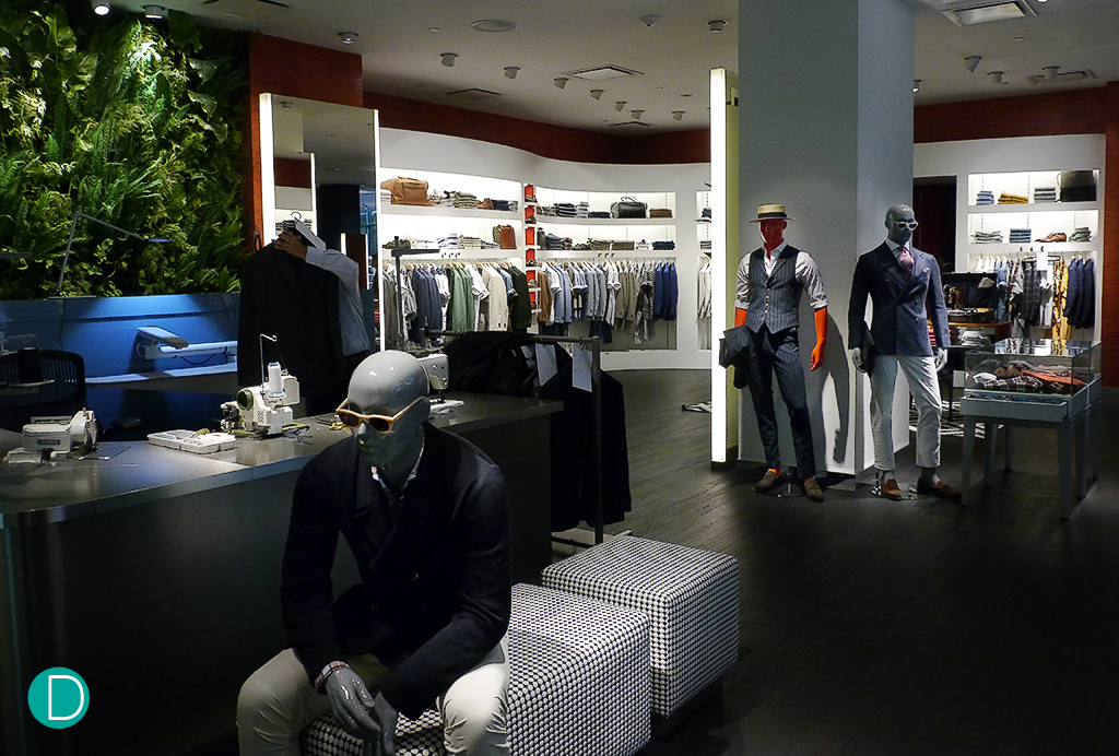 The entrance to Suit Supply at Ion Orchard, Singapore. Note the alterations workstation on the left, where two alterations masters work to make adjustments so that the ready to wear clothing fits you.