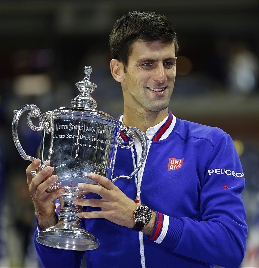Novak Djokovic, of Serbia, holds up the championship trophy after defeating Roger Federer, of Switzerland, in the men’s championship match of the U.S. Open tennis tournament, Sunday, Sept. 13, 2015, in New York. (AP Photo/Julio Cortez)