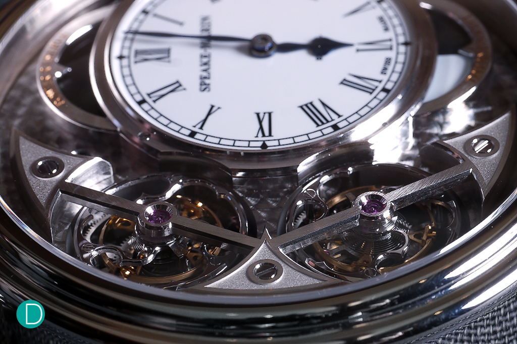 The double tourbillons, prominently displayed on the left of the case. The tourbillon carriages carry the stylized motif of the topping tool which is Speake-Marin's calling card. 