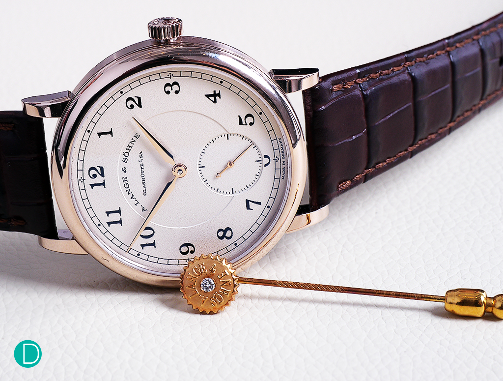 The Lange 1815 200th Anniversary F.A. Lange in honey coloured gold. The pin is in 18 k yellow gold, with a 15 year old patina. The pin is a piece unique, hand made by Master Engraver Helmut Wagner, and is made to resemble the crown of a Lange watch, and adorned with a diamond endstone used in Quality 1A Lange watches. The pin was presented by the late Günter Blümlein to the author in 1999.