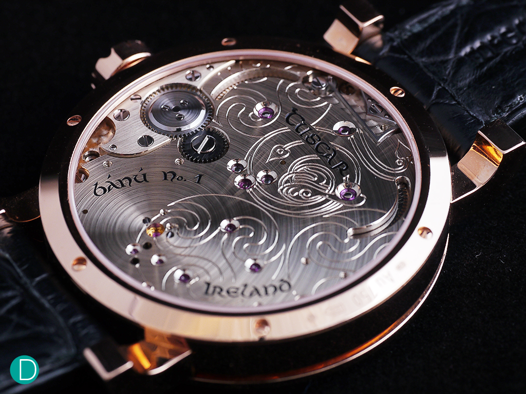 The McG01: The movement is turned upside down. The side which is typically the dial side is on the back, and the side which normally sits below the dial is flipped over to be the dial side. This meant that the back of the watch shows a full plate, which the McGonigles decorated with celtic designs engraved on the maillechort plates.