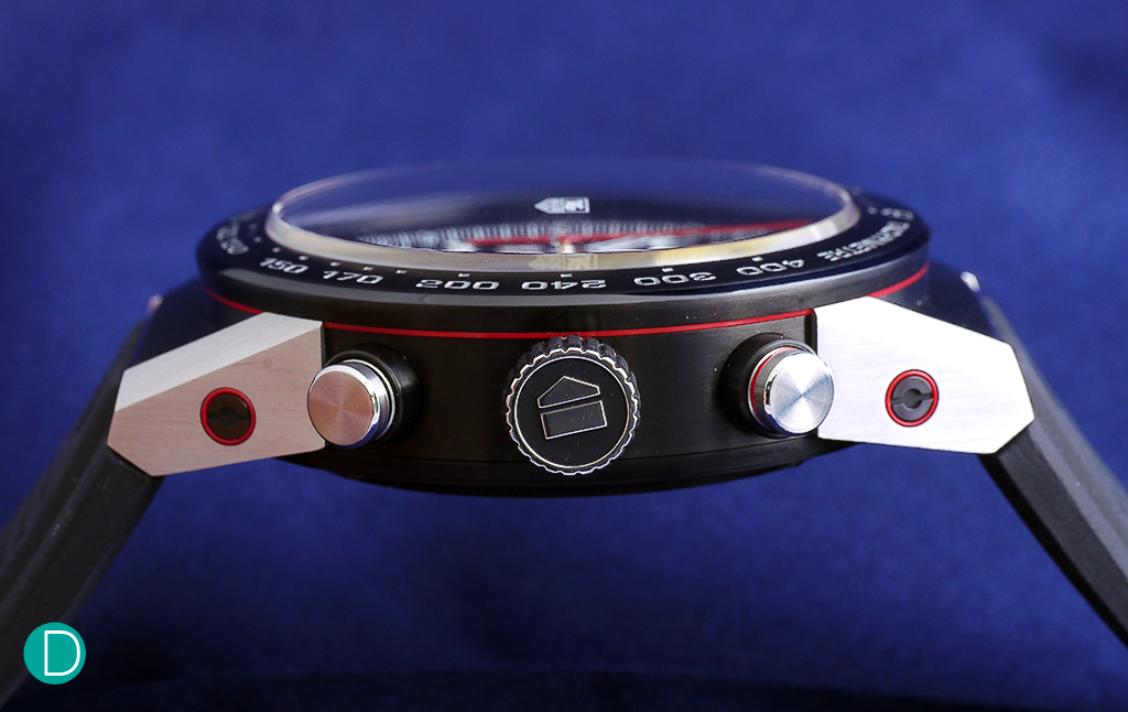 The case side, with a red stripe running across the edge between the middle case and bezel. The case is in stainless steel with a brushed polish finish. The caps and bezel is also in steel but with black brushed titanium carbide coating.