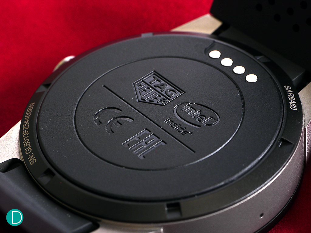Caseback of the Tag Heuer Connected. The 4 contact points come into contact via the charging device while charging, to which it is magnetically attached, like the power cord of an MacBook.