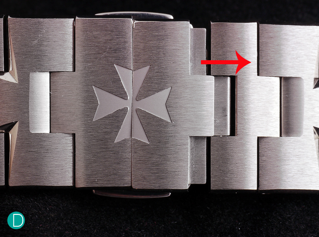 The bracelet expansion system. The right side shows the expanded link when a firm but light force is applied in the direction of the red arrow, while the left side remains un-expanded.