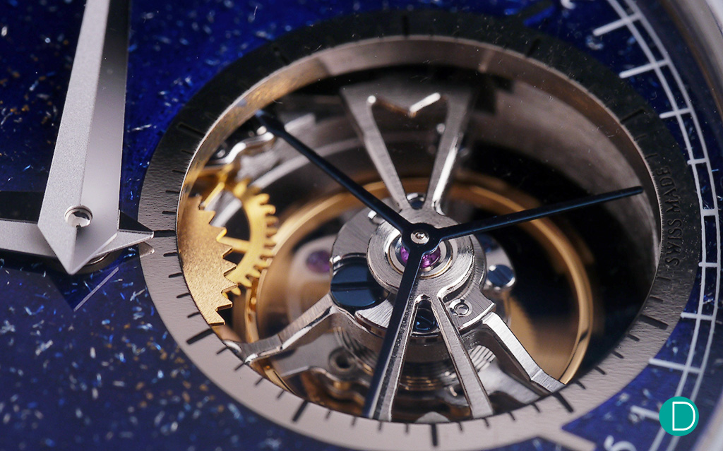 The tourbillon on its bridge, and carries the characteristic three hands to show the passing of the seconds.